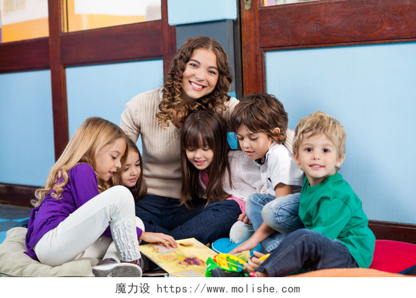 教室里老师和同学坐在一起开心的玩耍老师与孩子坐在地板上